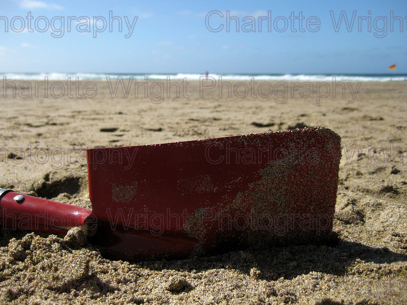 IMG 2055 
 My red spade in the sand on Chapel Porth beach in Cornwall. I shot this lying down, and actually upside down! Photographed by myself, Charlotte Wright Photography 
 Keywords: spade, sand, beach, sea, waves, cornwall, red, chapel porth, United Kingdom, photography